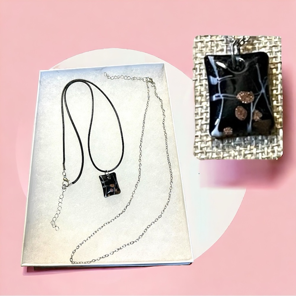 New in box!  Italian glass pendant with set of two chains.  Black, white, bronze